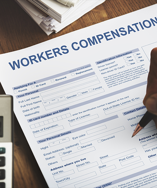 Filling out a workers' compensation form on a wooden desk.